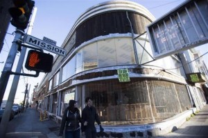Pedestrians walk past an empty storefront in the Mission District in San Francisco