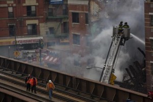 New York City firefighters examine the rubble at an apparent building explosion fire and collapse in the Harlem section of New York