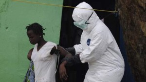 Health worker brings a woman suspected of having contracted the Ebola virus to an ambulance in Monrovia