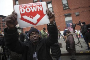 A protester hold up sign at makeshift memorial at site where two police officers were shot in Brooklyn borough of New York
