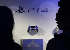 Visitors looks at Sony Corp's PlayStation 4 game consoles and control pads displayed at a booth during the Tokyo Game Show 2014 in Makuhari
