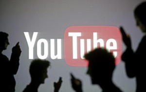 People are silhouetted as they pose with mobile devices in front of a screen projected with a Youtube logo, in this picture illustration taken in Zenica October 29, 2014.     REUTERS/Dado Ruvic