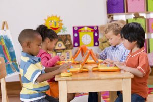 Children playing with toy laptops in class