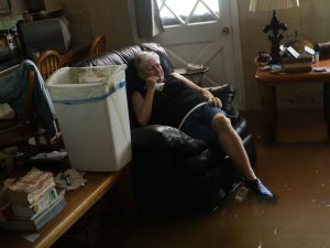 Elsie Lazarus is overcome with emotion Thursday as she sits in her flooded living room while retrieving what she can from her home in St. Amant, La.